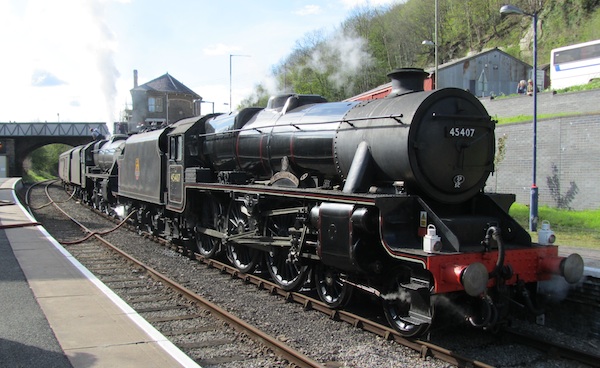 Steam locomotives drawing a railway enthusiast train; a train spotters paradise.